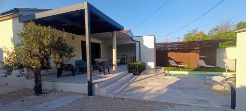 une terrasse d'une maison avec un pavillon dans l'établissement L'Orée des Alpilles Proche Centre ville St Rémy de Provence, à Saint-Rémy-de-Provence