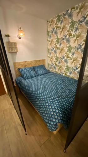 une chambre avec un lit avec une couette bleue dans l'établissement Appartement proche plage, aéroport, tram, à Nice