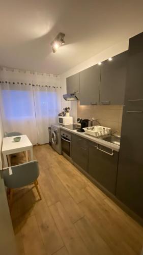 - une cuisine avec un comptoir, une table et une cuisinière dans l'établissement Appartement proche plage, aéroport, tram, à Nice