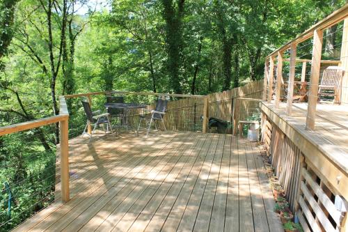 une terrasse en bois avec une table et des chaises dessus dans l'établissement Les Terrasses, à Saint-Antonin