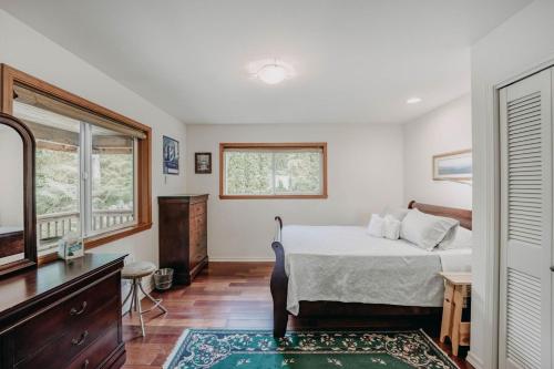 a bedroom with a bed and a dresser and a mirror at Mt Baker Rim Cabin 77, The Mountain View Delight in Bellingham