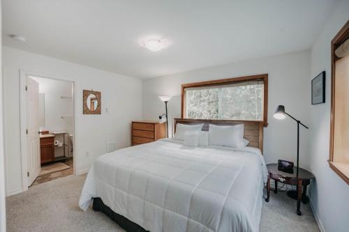 a bedroom with a large white bed and a window at Mt Baker Rim Cabin 77, The Mountain View Delight in Bellingham