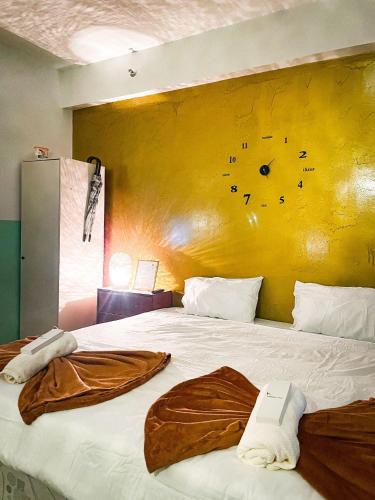 a bedroom with a large bed with a yellow wall at Poolside Apartment - Sleeps 4 Ac & Hot Shower in Marilao