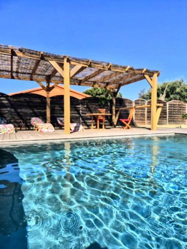 une piscine avec une pergola et une piscine dans l'établissement A Bella Gaia, à Cauro