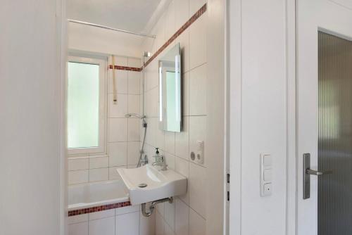 ein weißes Badezimmer mit Waschbecken und Spiegel in der Unterkunft Ferienwohnung Rheinblick in Sankt Goar