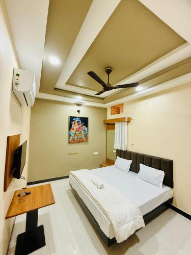 a bedroom with a bed and a ceiling fan at Hotel Vrinda Maheshwar in Maheshwar