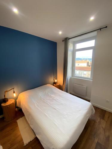 a bedroom with a large white bed and a window at Industrial cocoon - Appartement Calme entre Lyon et Saint Etienne in Saint-Chamond