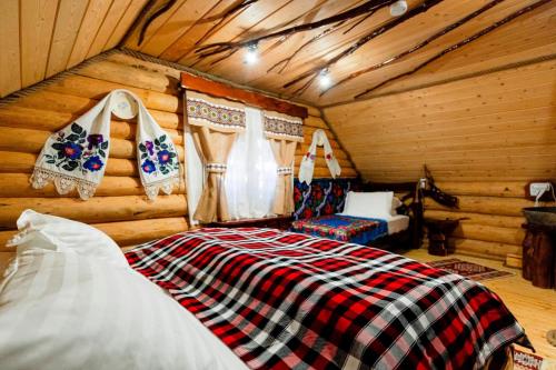 a bedroom with a bed in a log cabin at Cabanele Hăi Mă & Hăi Cocoa in Ocna Şugatag
