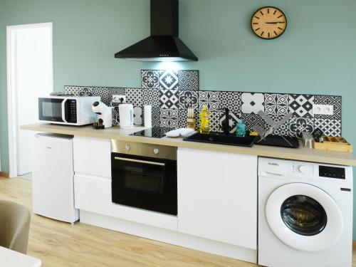 une cuisine avec une cuisinière et une machine à laver dans l'établissement L'élégant, T2 avec climatisation, wifi, à Cognac