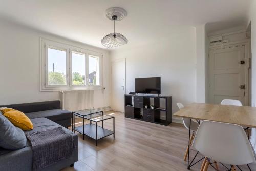 un salon avec un canapé et une table dans l'établissement Bright apartment - South Lyon close to all amenities, à Oullins