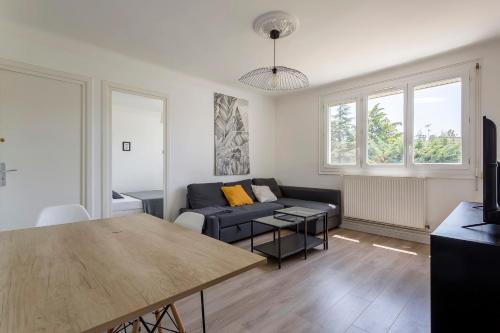 un salon avec un canapé et une table dans l'établissement Bright apartment - South Lyon close to all amenities, à Oullins