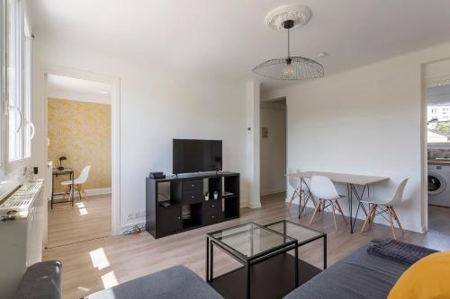 un salon avec un canapé et une table avec des chaises dans l'établissement Bright apartment - South Lyon close to all amenities, à Oullins