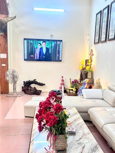 a living room with a couch and a tv on the wall at Khách Sạn Việt An in Thương Xà (2)