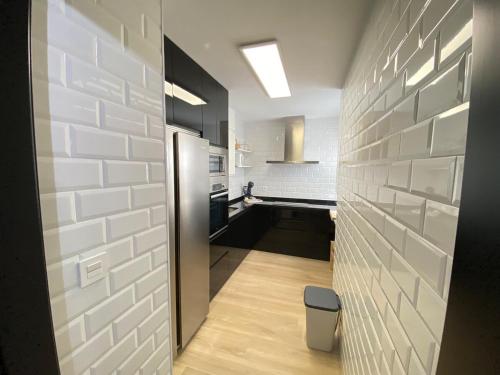 a hallway leading to a kitchen with white brick walls at Apartmento Carmen Viejo, Centro in Sanlúcar de Barrameda