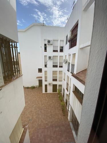 an empty courtyard of a white building at Apartmento Carmen Viejo, Centro in Sanlúcar de Barrameda