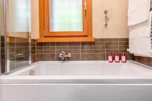 a white bath tub in a bathroom with a window at Red Chic Roma in Rome
