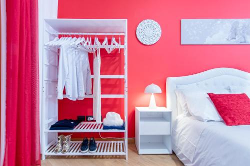 a red bedroom with a white bed and a red wall at Red Chic Roma in Rome