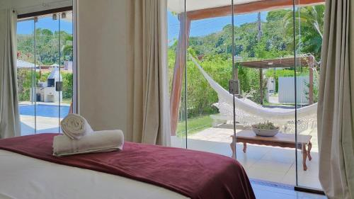 a bedroom with a bed and a view of a hammock at Casa Asa Delta - Pipa Natureza in Pipa