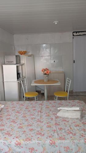 a room with a bed and a table and chairs at Kitnete canto verde in Ponta Grossa