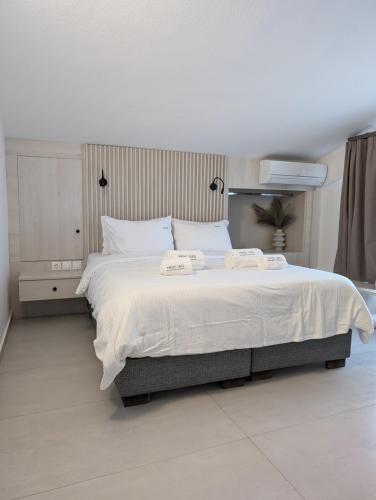 a bedroom with a large bed with two towels on it at Twins Yard in Nikiti