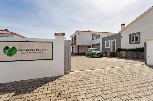 a sign for a building with a car in a driveway at Quinta dos Raposos- Nazaré Portugal in Nazaré