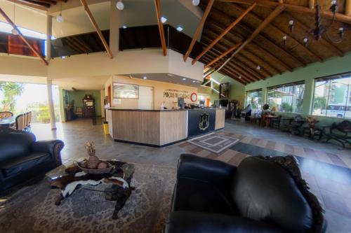 a living room with couches and a table and a kitchen at Hotel Fazenda Poços de Caldas in Poços de Caldas