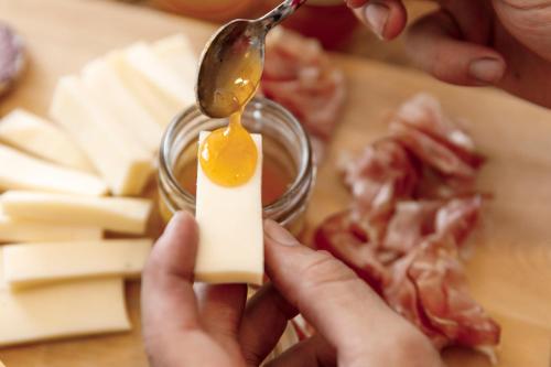 a person holding a spoon with an egg on a piece of bacon at Casa21 in SantʼAntonio Tortal