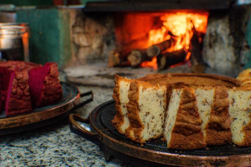 a slice of cake on a plate in front of a fireplace at Hotel Fazenda Poços de Caldas in Poços de Caldas