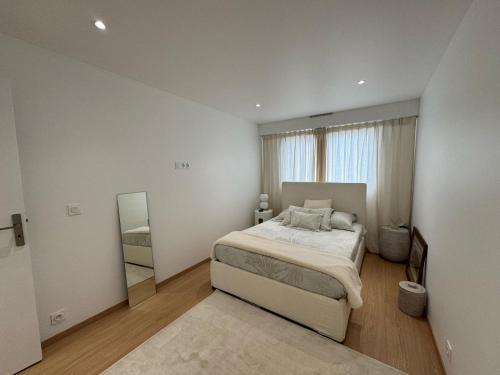 une chambre blanche avec un lit et un miroir dans l'établissement vue mer, à Vallauris