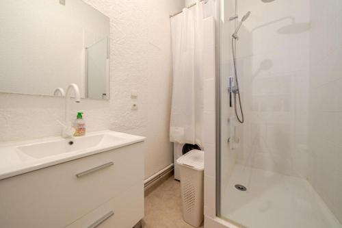 une salle de bain blanche avec une douche et un lavabo dans l'établissement Nouveau T2 Centre Historique, à Thiers