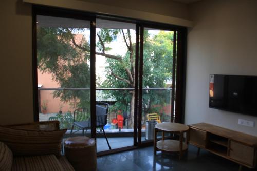 a living room with a large sliding glass door at Hotel Tattva Suites in Pune