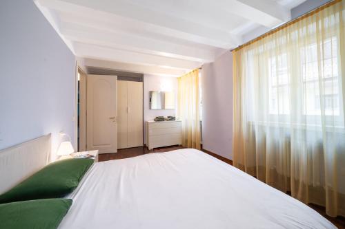 Un dormitorio con una cama blanca y una ventana. en Gardastay-Dolly's house, en Riva del Garda