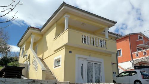 a yellow house with stairs in front of a building at Apartment Sarah in Čavle