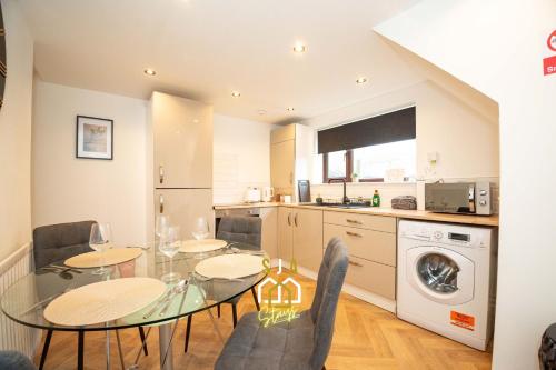 a kitchen and dining room with a glass table and chairs at Queen Street Stay - SJA Stays - Modern 2 Bed Apartment in Peterhead