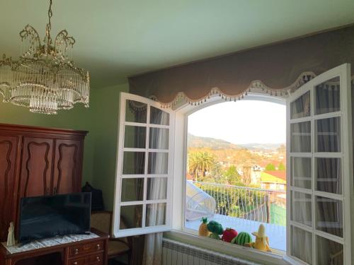 ein Zimmer mit einem großen Fenster mit Aussicht in der Unterkunft La maison d'Abelleira in Puenteareas
