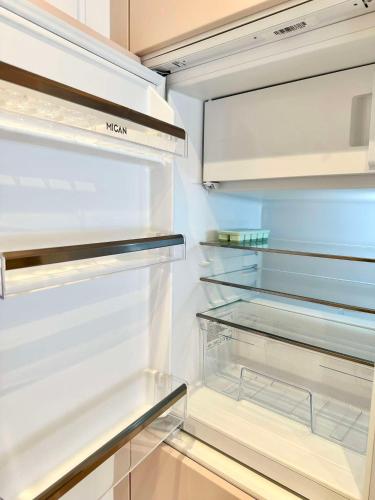 an empty refrigerator with its door open at Miami Vice Appartement mit Balkon & Flussblick-Das Alpenzeit im Zentrum mit Parkplatz in Bad Aussee