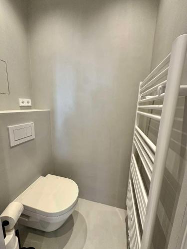 a small bathroom with a toilet and a crib at Miami Vice Appartement mit Balkon & Flussblick-Das Alpenzeit im Zentrum mit Parkplatz in Bad Aussee
