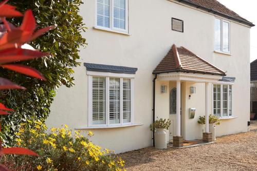 a white house with a door and windows at Rockstone Cottage in Freshwater