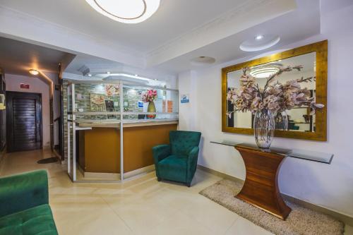 a waiting room with green chairs and a vase of flowers at Hotel B´liam in Tumbes