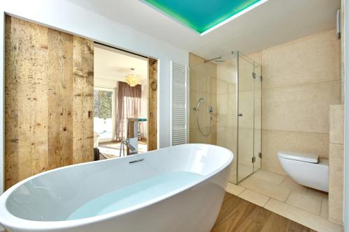 a bathroom with a tub and a glass shower at Alpenrefugium in Murnau am Staffelsee