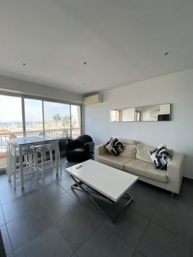 un salon avec un canapé et une table dans l'établissement Luxueux appartement 2 chambres, vue mer, à La Grande Motte