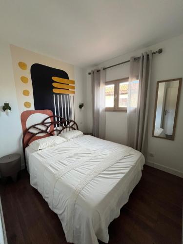 - une chambre avec un grand lit blanc et une chaise dans l'établissement Maison Terracotta des Karantes, à Narbonne-Plage