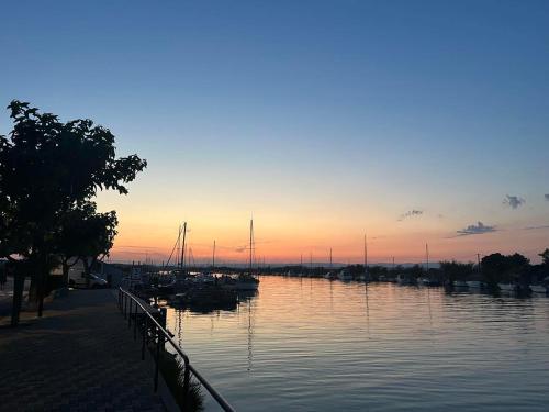 a marina with boats in the water at sunset at Maison Terracotta des Karantes in Narbonne-Plage