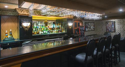 a man standing at a bar in a restaurant at The Orchid Hotel Mumbai Vile Parle in Mumbai
