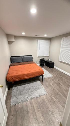a bedroom with a bed with an orange bedspread at Rooms available in a single Family home shared with Host in Willingboro