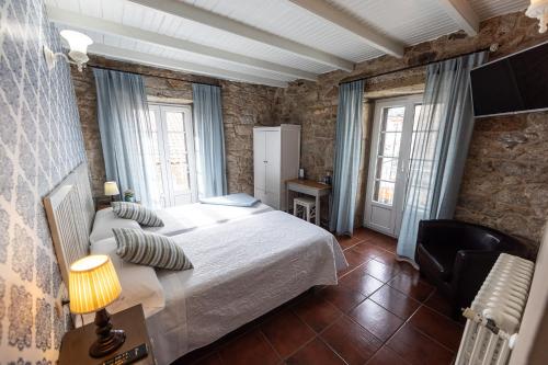 a bedroom with a large bed and two windows at Hotel Puerto Arnela in Camariñas