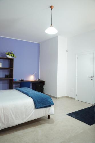 a bedroom with a bed with a blue blanket at Sulle Tracce Di Federico in Andria