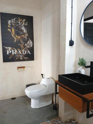a bathroom with a white toilet and a black sink at Nice Place To Stay - Rooftop Apartments in Seminyak