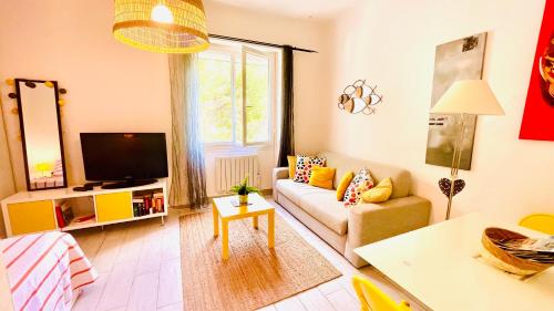 een woonkamer met een bank en een tv bij Au son des Cigales in Cassis