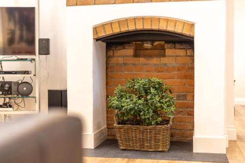 a plant in a basket next to a brick wall at Swafield Hall in Swafield